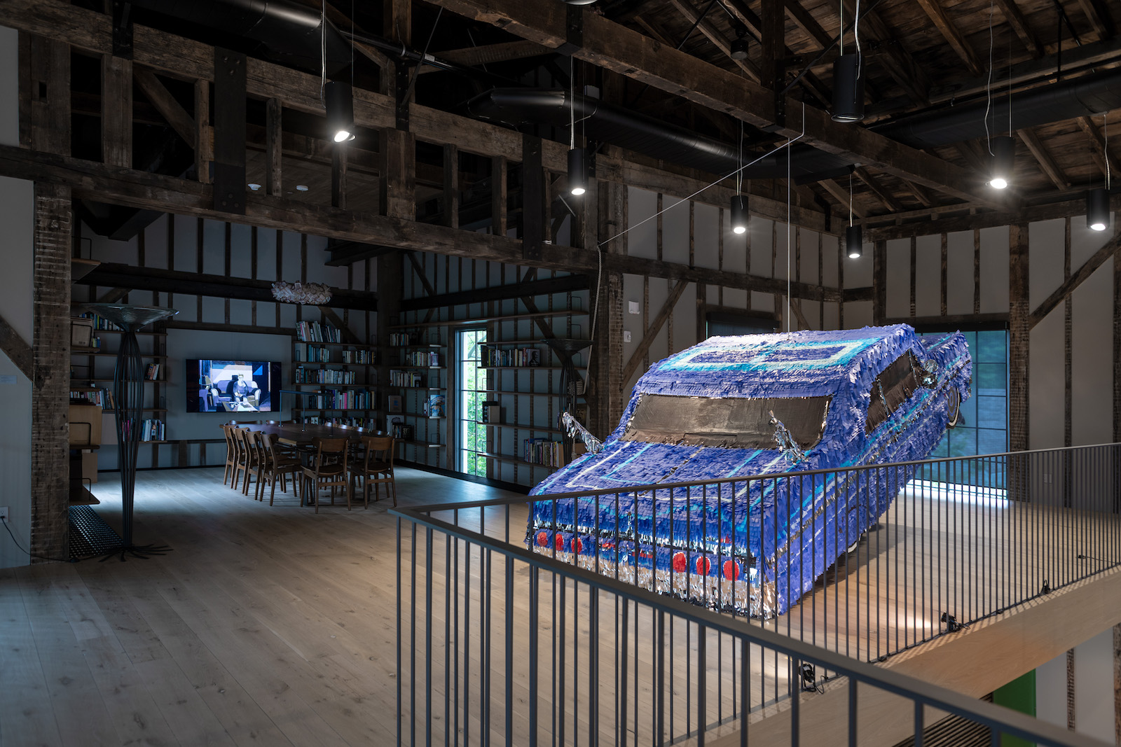 installation view of road rage at the church, showing sparkling blue car made of confetti pieces hanging