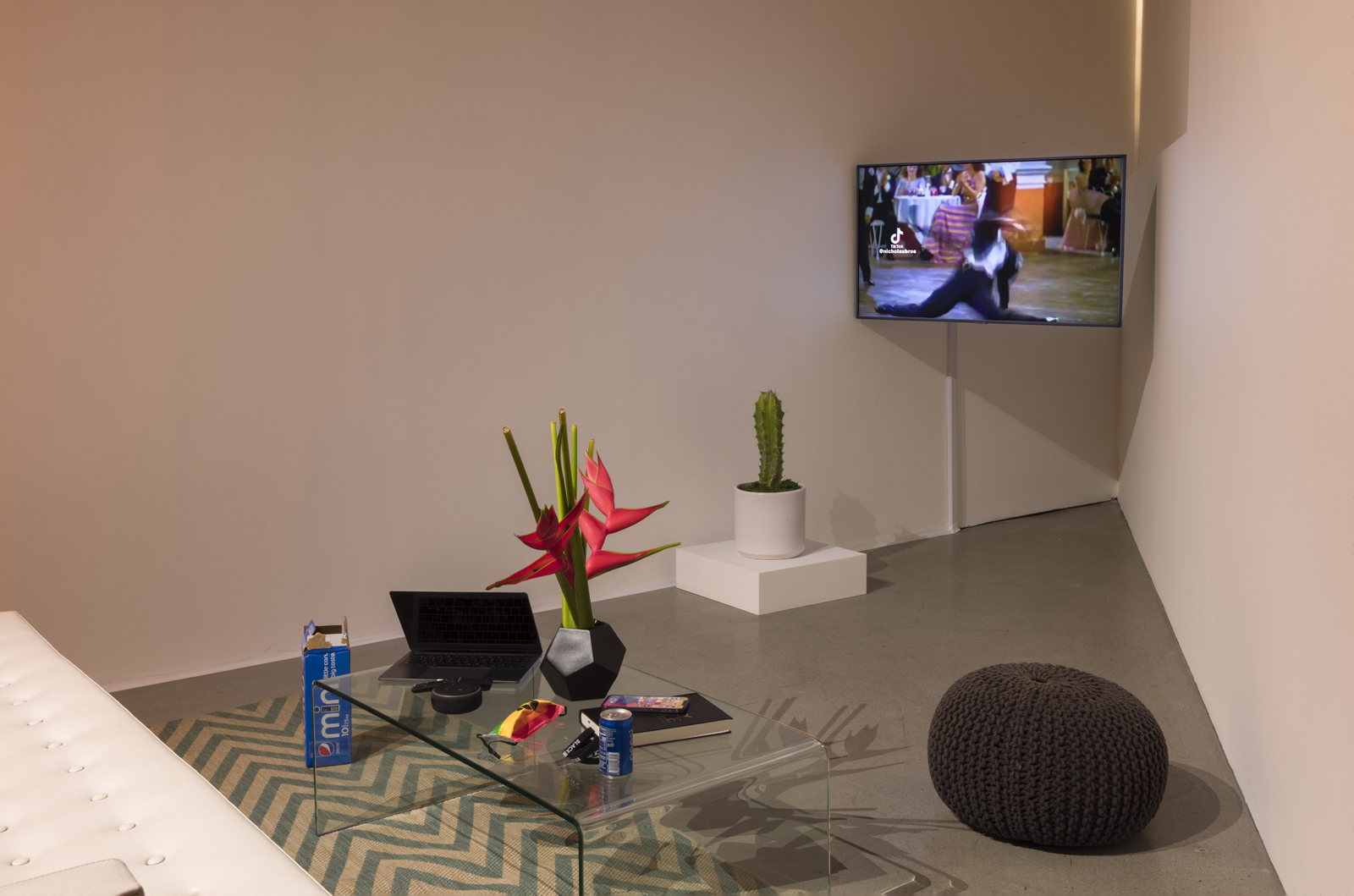 installation space of blitz bazawule at uta artist space of couch and glass table with objects and television